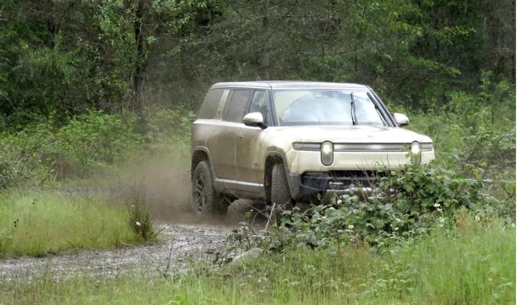 Rivian R1S in the mud, at DirtFish